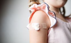 little girl with plaster on the shoulder from the injection